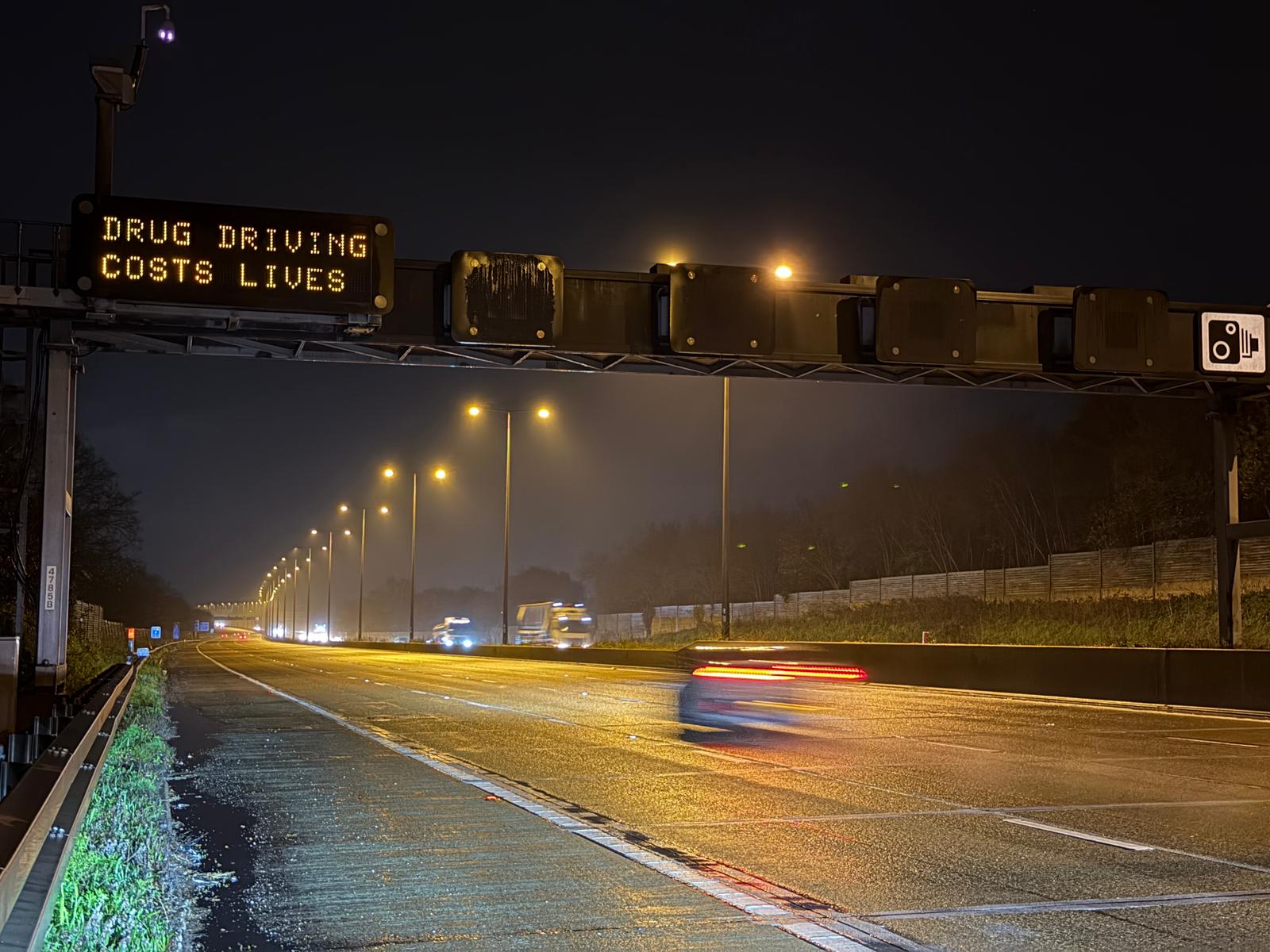 A motorway gantry in Surrey, displaying the message 'Drug Driving Costs Lives'